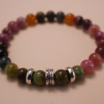 Close-up detail of multicolor tourmaline bracelet showing the polished surface, vibrant gemstone hues, and natural color transitions from pink to green.1