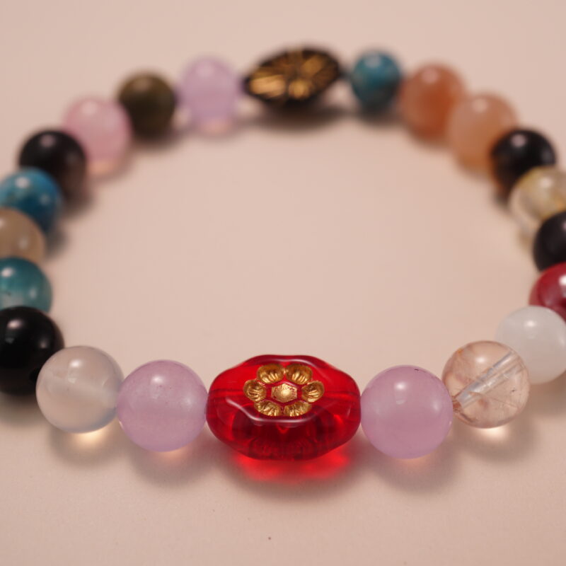Close-up detail of multicolor gemstone bracelet showing the variety of natural stones and decorative beads, highlighting the polished finish and vivid color contrasts.1