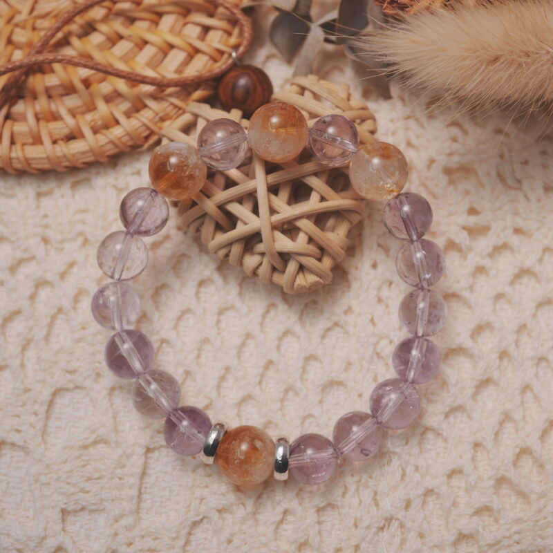 Amethyst and citrine bracelet displayed in a lifestyle setting under daylight, showcasing its soothing and radiant energy with harmonious purple and yellow hues.