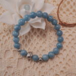 Aquamarine bracelet with silver beads displayed in a natural lifestyle setting under daylight, capturing its calming ocean-blue tones and elegant design.