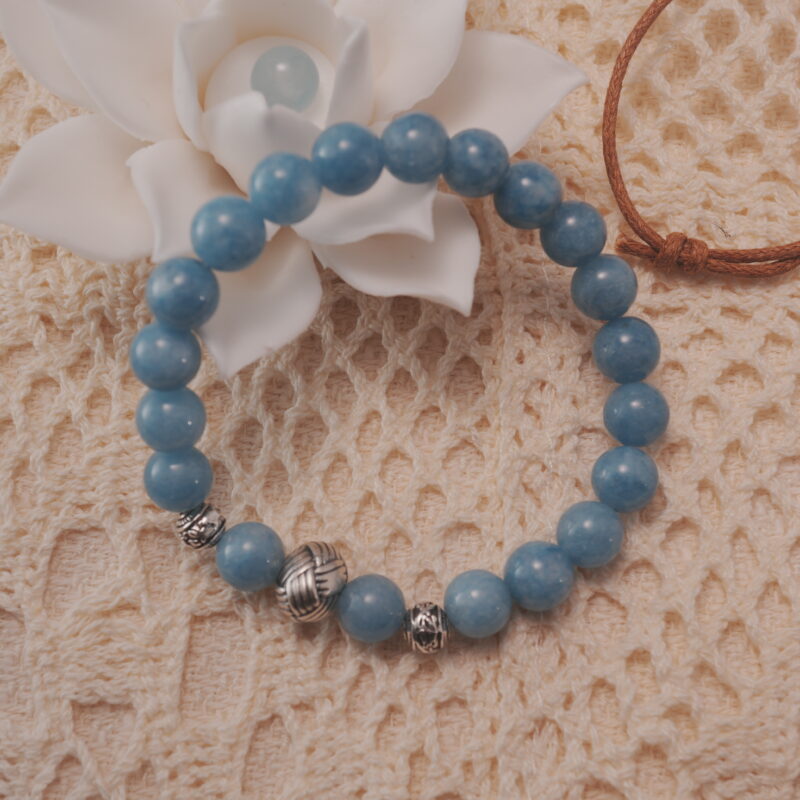 Aquamarine bracelet with silver beads displayed in a natural lifestyle setting under daylight, capturing its calming ocean-blue tones and elegant design.