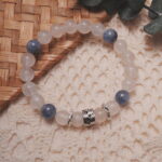 Moonstone and kyanite bracelet displayed in a natural lifestyle setting under daylight, capturing the serene balance of soft moonstone glow and calming blue kyanite energy.