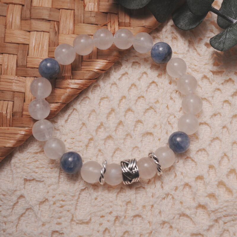 Moonstone and kyanite bracelet displayed in a natural lifestyle setting under daylight, capturing the serene balance of soft moonstone glow and calming blue kyanite energy.
