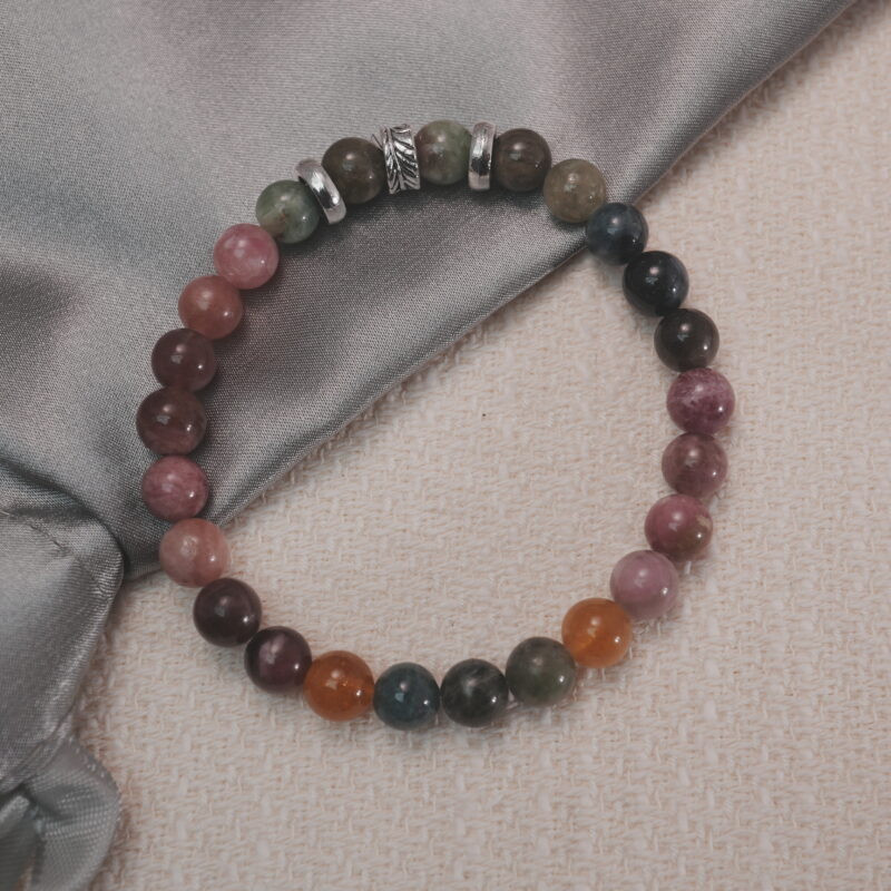 Multicolor tourmaline bracelet displayed in a natural lifestyle setting under daylight, highlighting its rich rainbow tones and soothing energy balance.