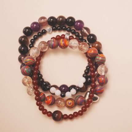 Vitality intention bracelet stack with red, brown, and purple gemstones, symbolizing strength, passion, and confidence.