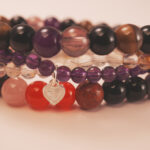 Heart charm detail from the Rainbow Fortune bracelet stack, symbolizing love, balance, and good fortune.