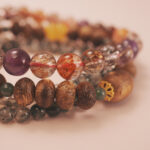 Close-up of the wealth bracelet stack showing warm tones and glowing energy of prosperity.
