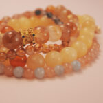 Close-up of the Golden Glow wealth bracelet stack showing luminous tones and flowing abundance energy.