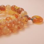 Close-up of the wealth bracelet stack showing golden tones and vibrant flow of abundance.