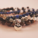 Heart charm detail from the Midnight Guardian bracelet stack, symbolizing calm protection and self-love.