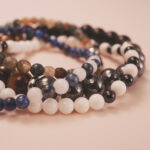 Close-up of the Midnight Guardian bracelet stack showing dark reflective tones and stable energy flow.