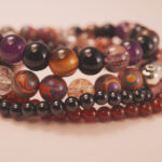 Close-up of red agate and tiger eye beads with silver accents, symbolizing passion, endurance, and courage.