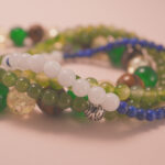 Close-up of green and citrine beads with silver accents, symbolizing renewal, joy, and lucky flow.