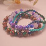 Good luck bracelet stack placed in a soft natural setting, radiating cheerful and uplifting energy.