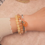 Model wearing the Golden Glow wealth bracelet stack — a daily charm for abundance and good fortune.