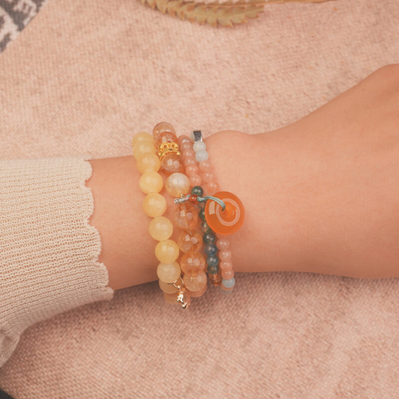 Model wearing the Golden Glow wealth bracelet stack — a daily charm for abundance and good fortune.