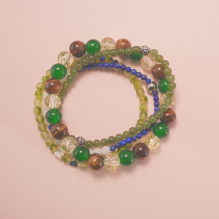 Good luck intention bracelet stack with green and golden gemstones, symbolizing growth, positivity, and fortune.